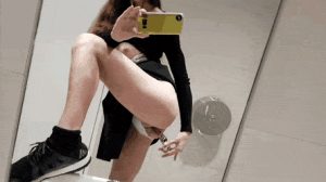 Masturbating while filming herself in the mirror in a public restroom